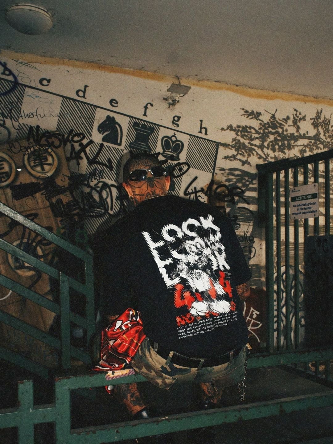 Black tee worn from behind, red and white back print.