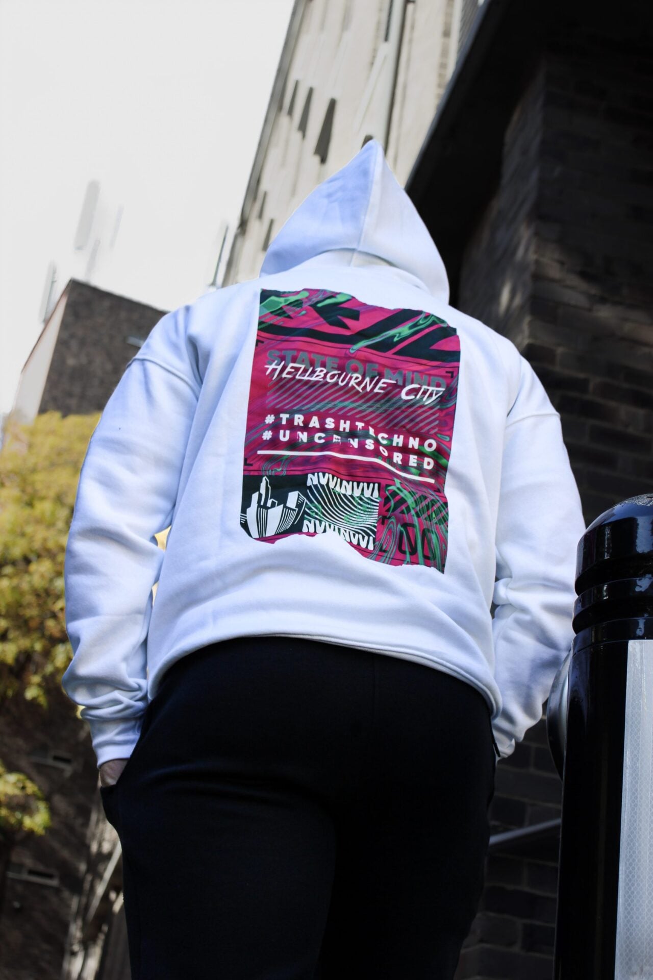 Dos du hoodie blanc en contre-plongée, capuche relevée, impression Hellbourne City.