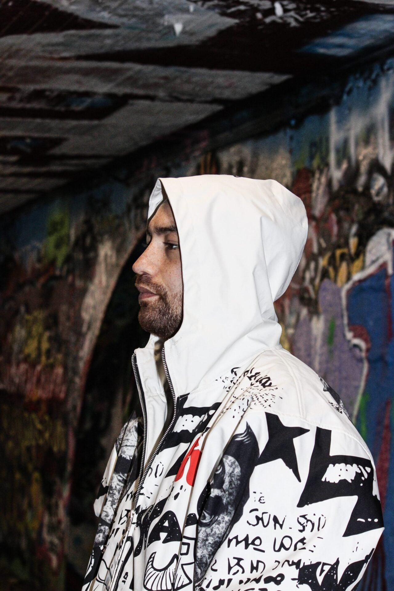 Veste graffiti blanche portée capuche relevée, vue de profil.
