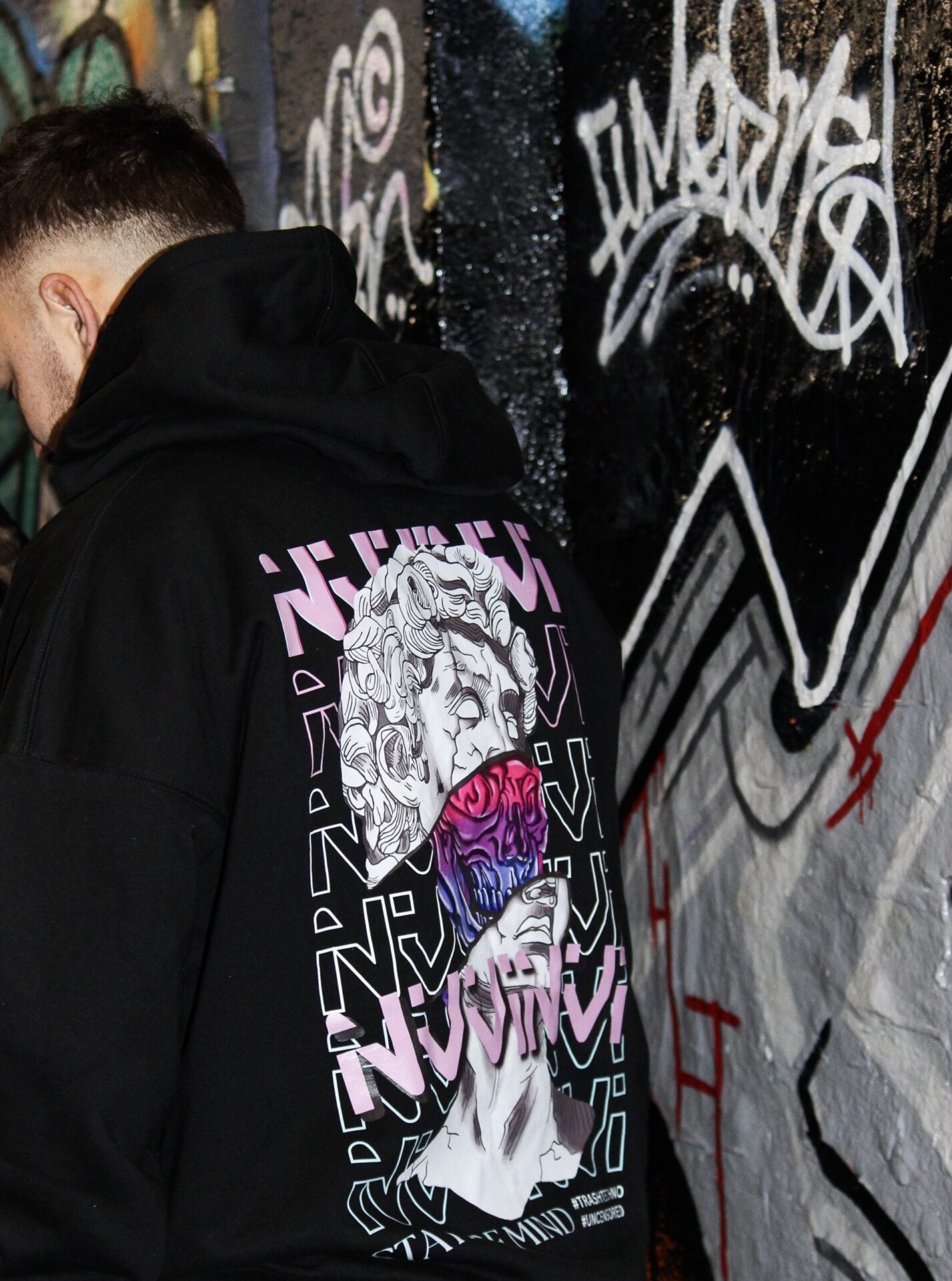 Dos du hoodie noir, impression rose et violette NVVINVVI, plan rapproché.