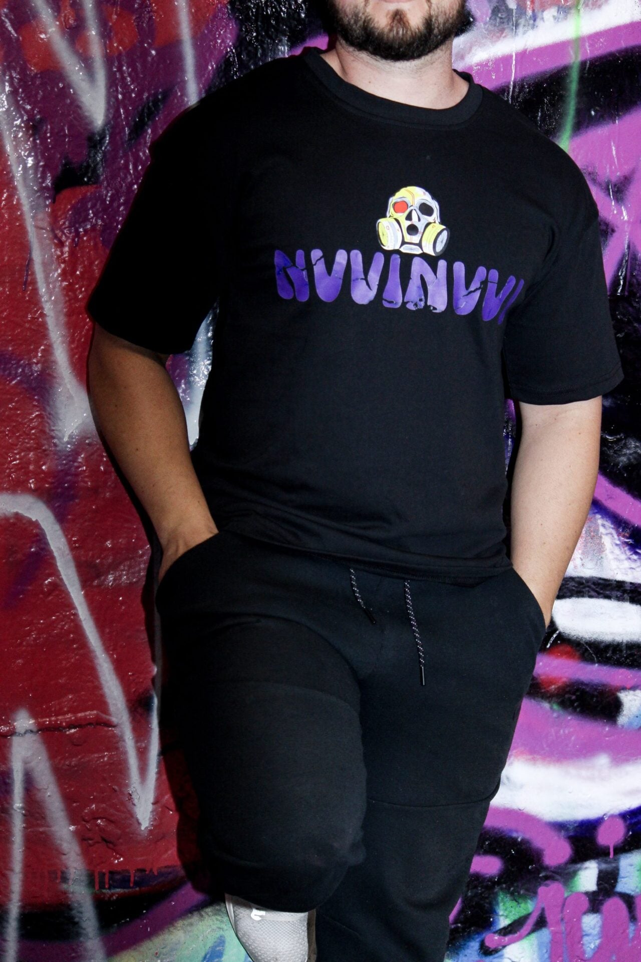 T-shirt noir porté de face, crâne et lettrage NVVINVVI violet sur la poitrine.